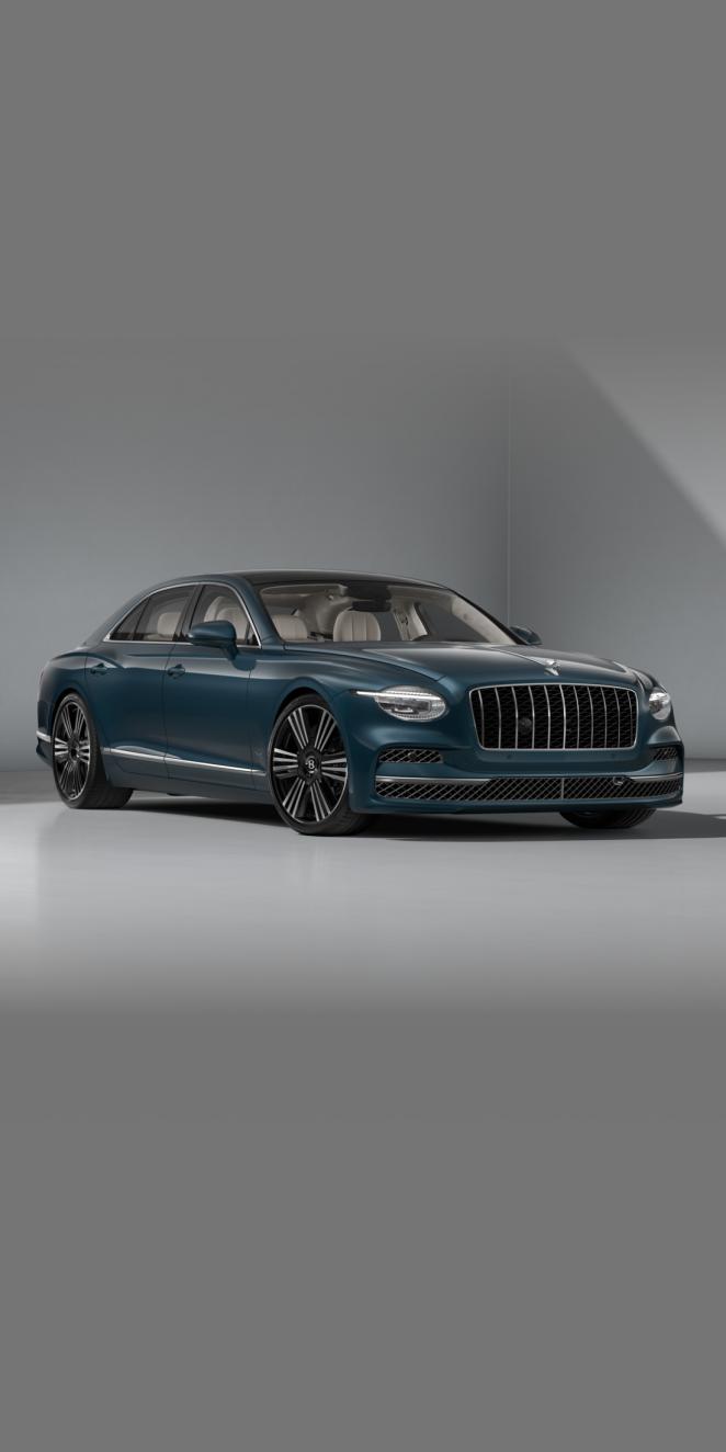 Front three-quarter of the Bentley Flying Spur Azure in Dark Teal showing the headlights and 22" Azure Black Machined wheel.