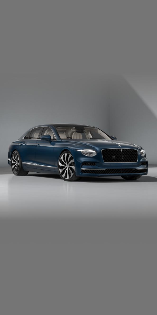 Front three-quarter of the Bentley Flying Spur in Marlin showing the headlights and 22" Ten Spoke Wheel painted in black and bright machined.