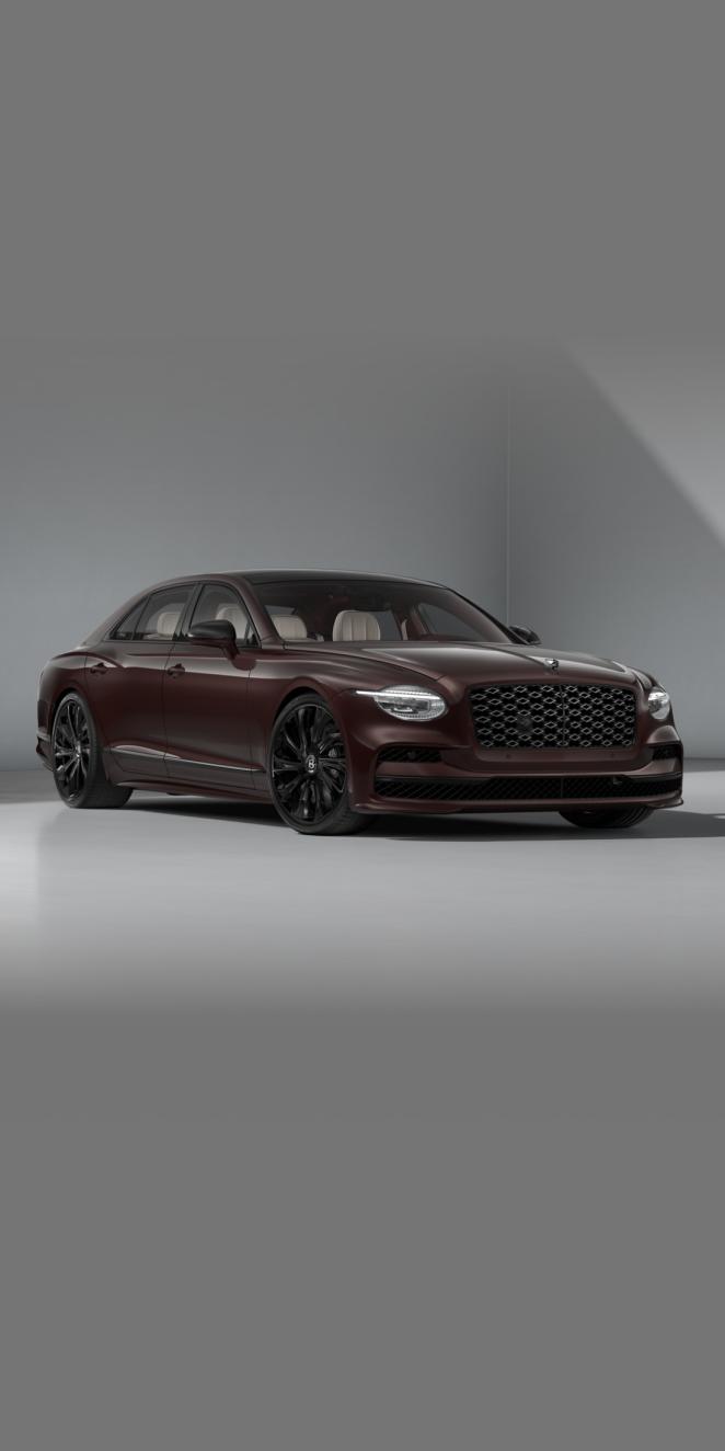 Front three-quarter of the Bentley Flying Spur Mulliner in Cricket Ball showing the headlights and 22" Mulliner wheel painted in black.