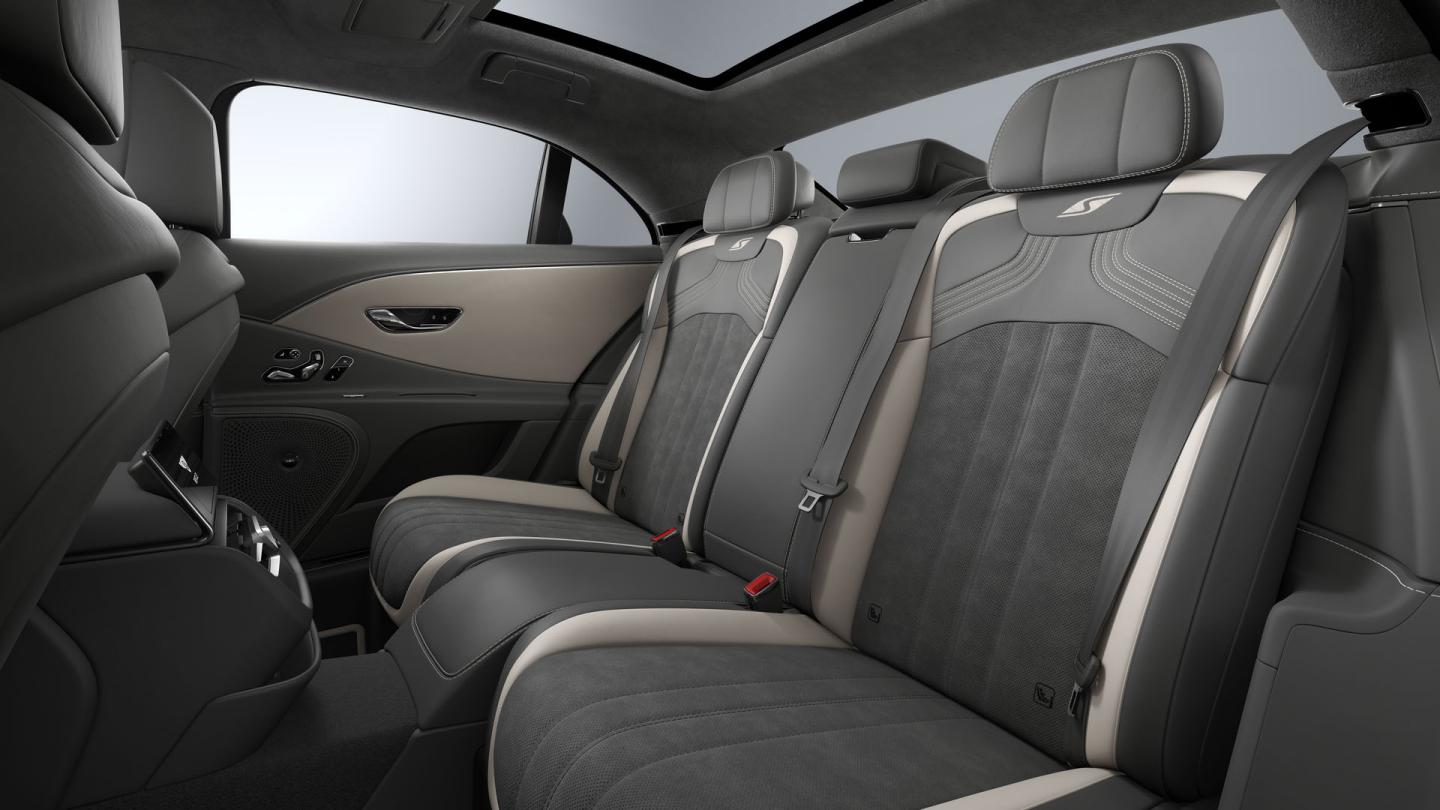 Rear passenger seat view inside the Bentley Flying Spur S with Linen and Gravity Grey upholstery and 4+1 seat configuration.