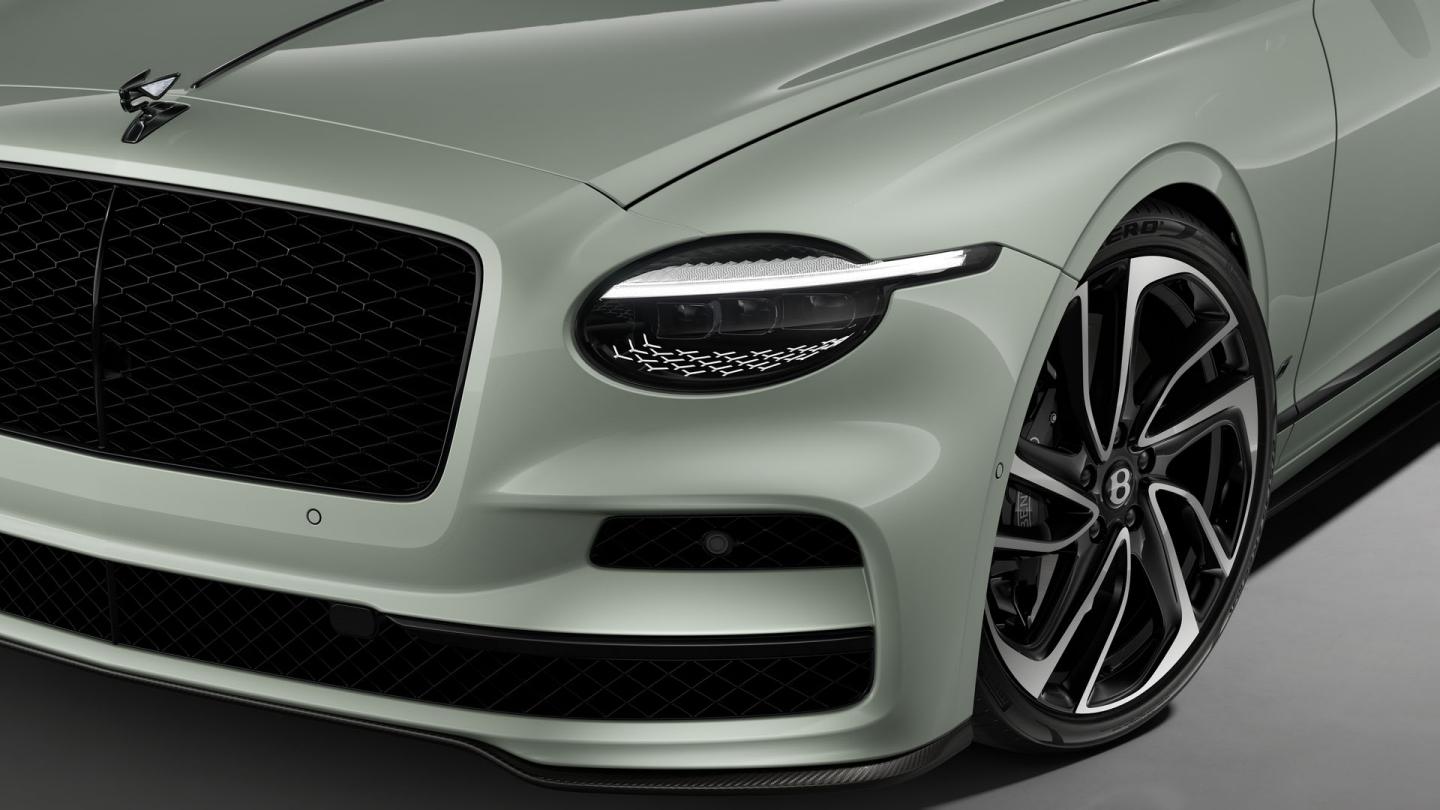Front three-quarter close-up of the Bentley Flying Spur S in Opalite showing the headlights, Carbon Styling Spec and 22" Ten Swept Spoke Black & Machined wheel.