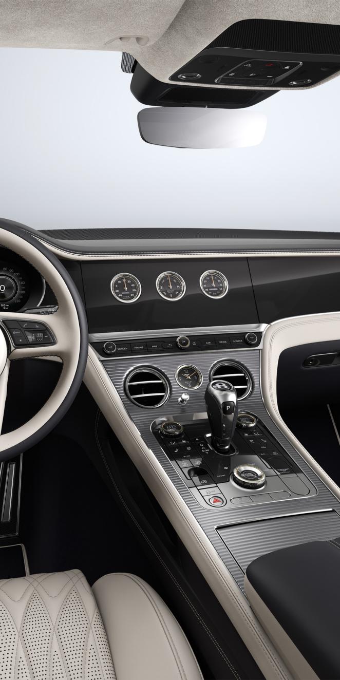 Driver’s view of the Bentley Continental GT Azure, showing the steering wheel with Dark Burr Walnut veneer and Linen and Cumbrian Green hide.