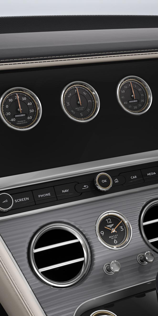 Close up of the rotating display in the Bentley Continental GT Azure, shown with the Dark Burr Walnut veneer and Linen and Cumbrian Green hide interior.