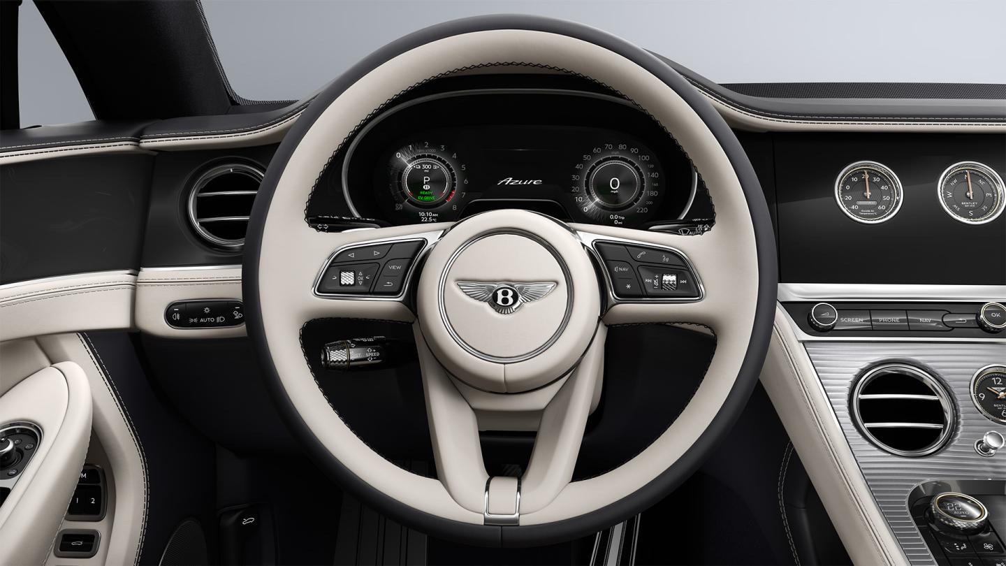 Driver’s view of the Bentley Continental GT Azure, showing the steering wheel with Imperial Blue veneer and Linen and Cumbrian Green hide.