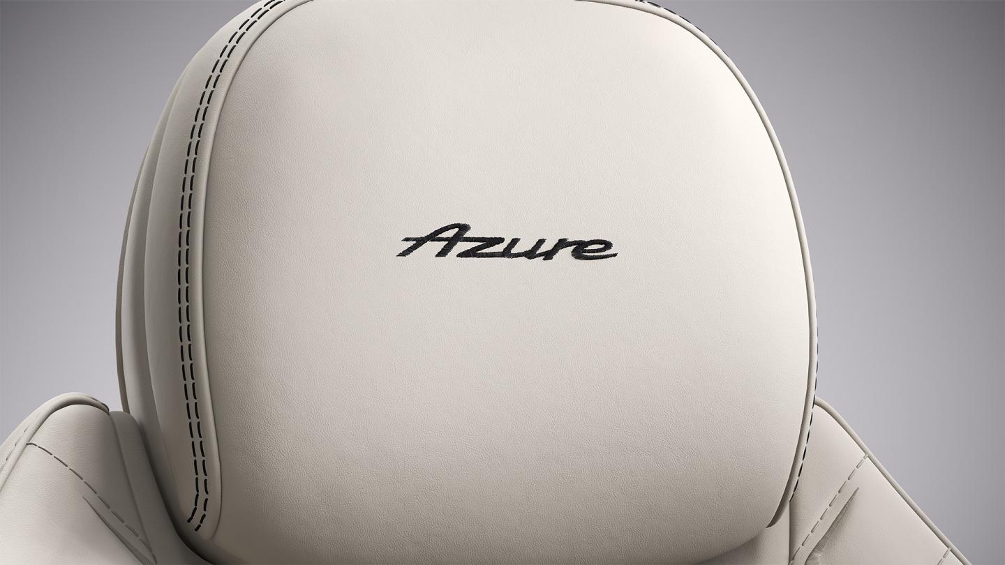 Close up of the Azure headrest in the Bentley Continental GT Azure, upholstered in Linen and Imperial Blue hide with “Azure” stitched into the headrest.