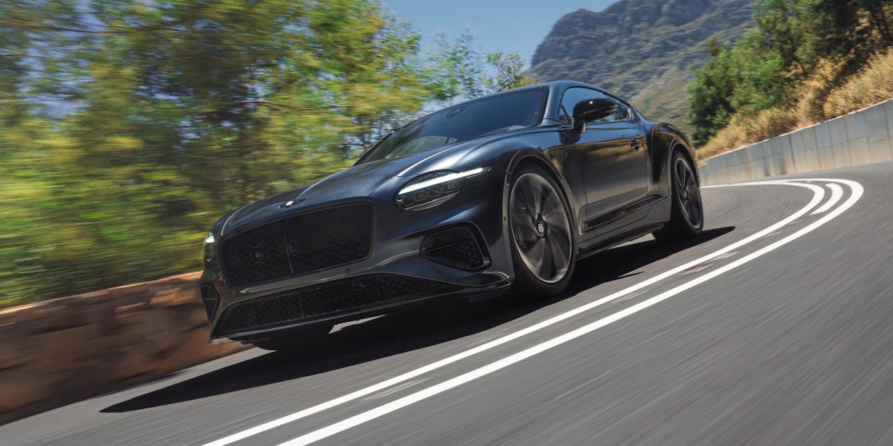 The new Hybrid Bentley Continental GT S in Thunder Grey driving dynamically in a rural environment
