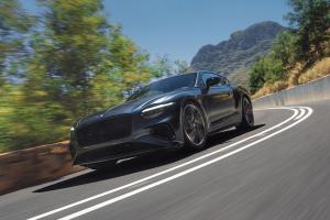 The new Hybrid Bentley Continental GT Speed in Tourmaline Green driving in an urban environment