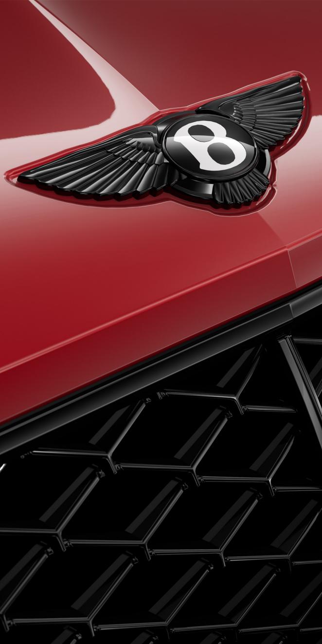 Close up of the Bentley logo on the bonnet of a Continental GT Speed in Monaco Yellow.