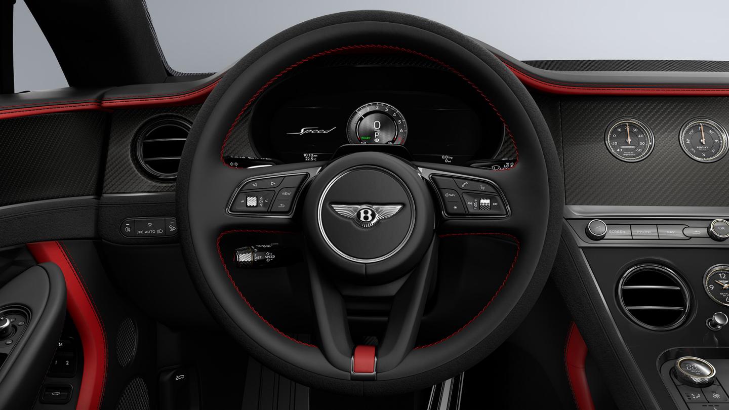 Driver’s view of the Bentley Continental GT Speed, showing the steering wheel with Carbon Fibre veneer and Hotspur Red and Beluga hide.