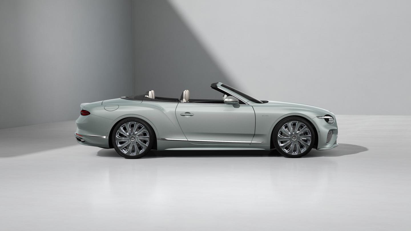 Side profile of the Bentley Continental GTC Mulliner in Breeze with a Grey convertible roof and 22" Mulliner Wheel painted Grey and Polished with Self Levelling Wheel Badge.