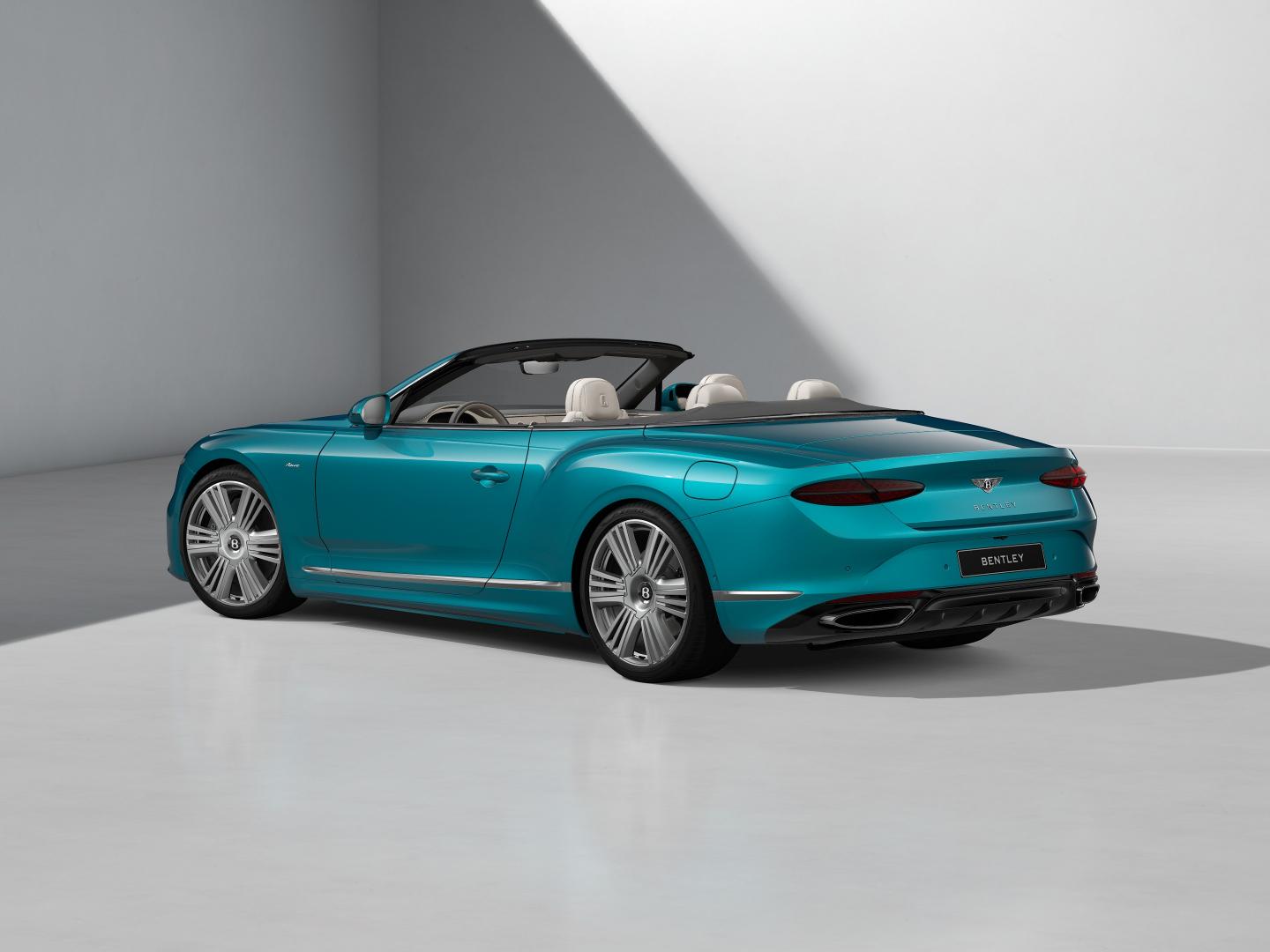 Rear three quarters shot of the Bentley Continental GTC Azure in Topaz Blue with a Tweed convertible roof and 22" Azure Wheel painted Silver and Bright Machined.