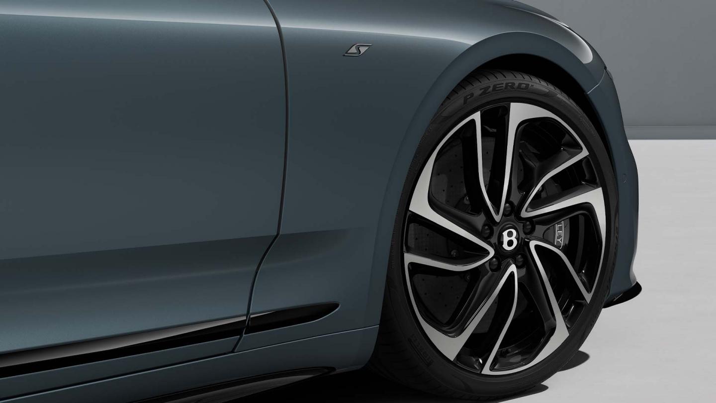 Close up of the front haunch of a Continental GTC S in Thunder Grey with a close up of the 22inch directional five spoke wheel and S badging