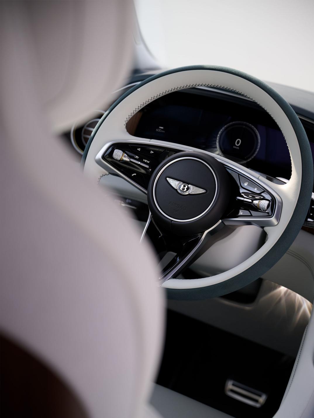 Interior view of the Bentley Torcal steering wheel with Glaze and Teal duo-tone trim and Open Pore Ombre Walnut veneer.
