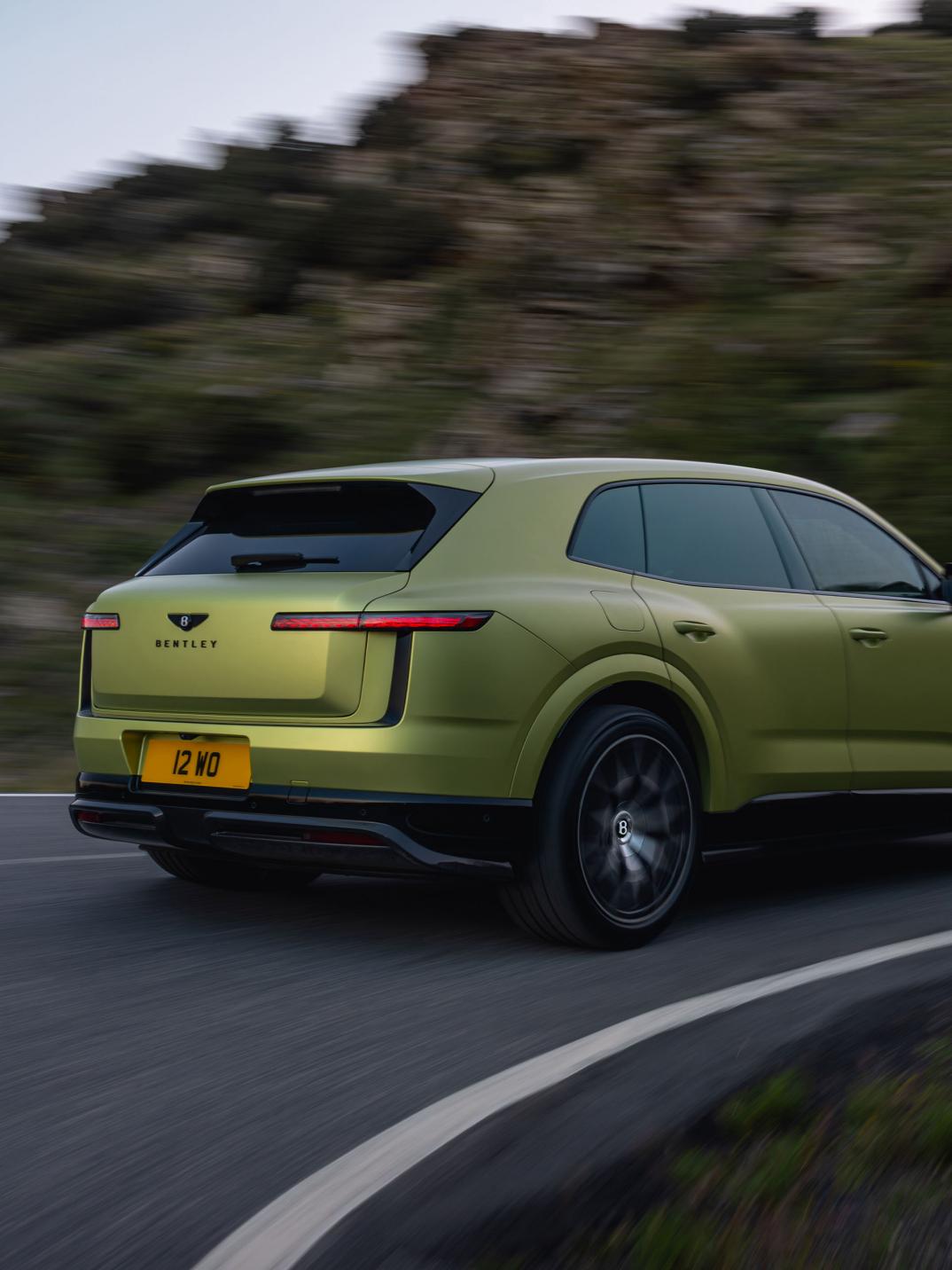 Rear three-quarter driving shot of the Bentley Torcal S in Electrum Satin.