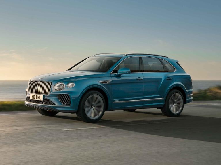 Bentley Bentayga EWB Azure side view in Topaz blue / Kingfisher- by Mulliner colour, featuring 22 inch ten spoke wheel - Painted with chrome accents driving along sea side.