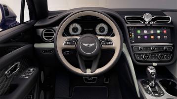 Heated duo tone steering wheel of Bentley Bentayga with multimedia and temperature controls.