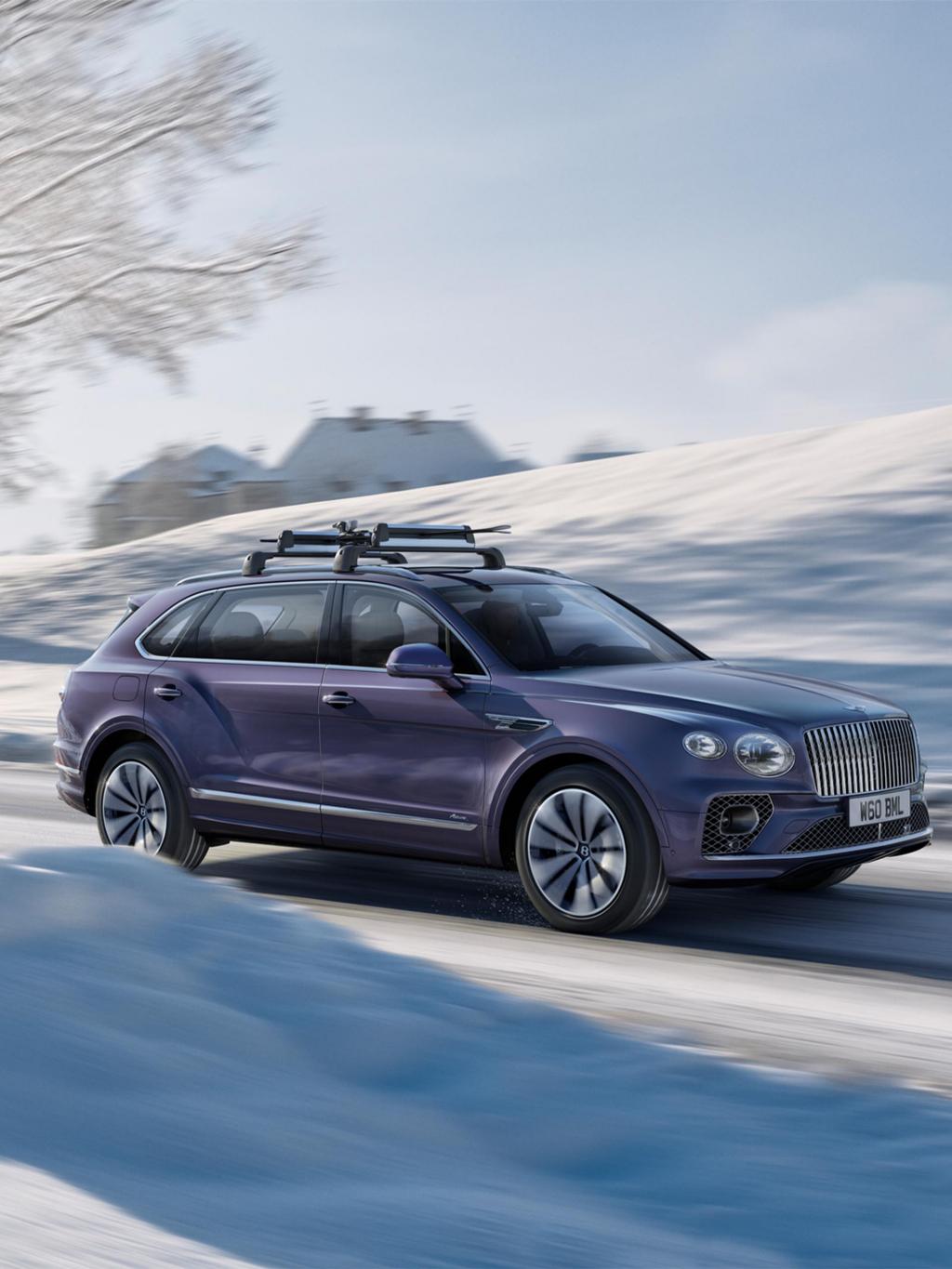 Bentley Bentayga EWB Azure on a snowy road with accessories such as a roof rack, winter tyres and styling specification