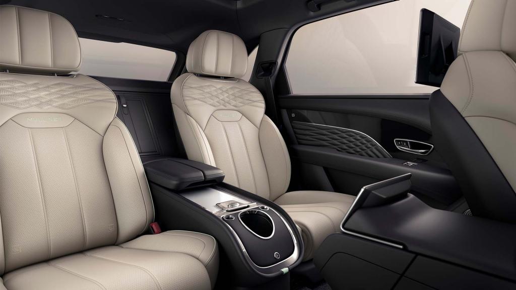 Bentley Bentayga EWB Mulliner rear passenger seats view featuring detailed stitching and Mulliner emblem in Damson