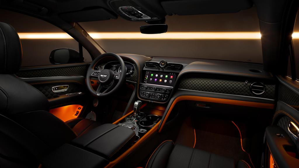 Interior front cabin view of Bentley Bentayga S, featuring Beluga leather and mandarin contrasting leather and Bentleys exclusive carbon weave on the dash fascia and in the door cards.