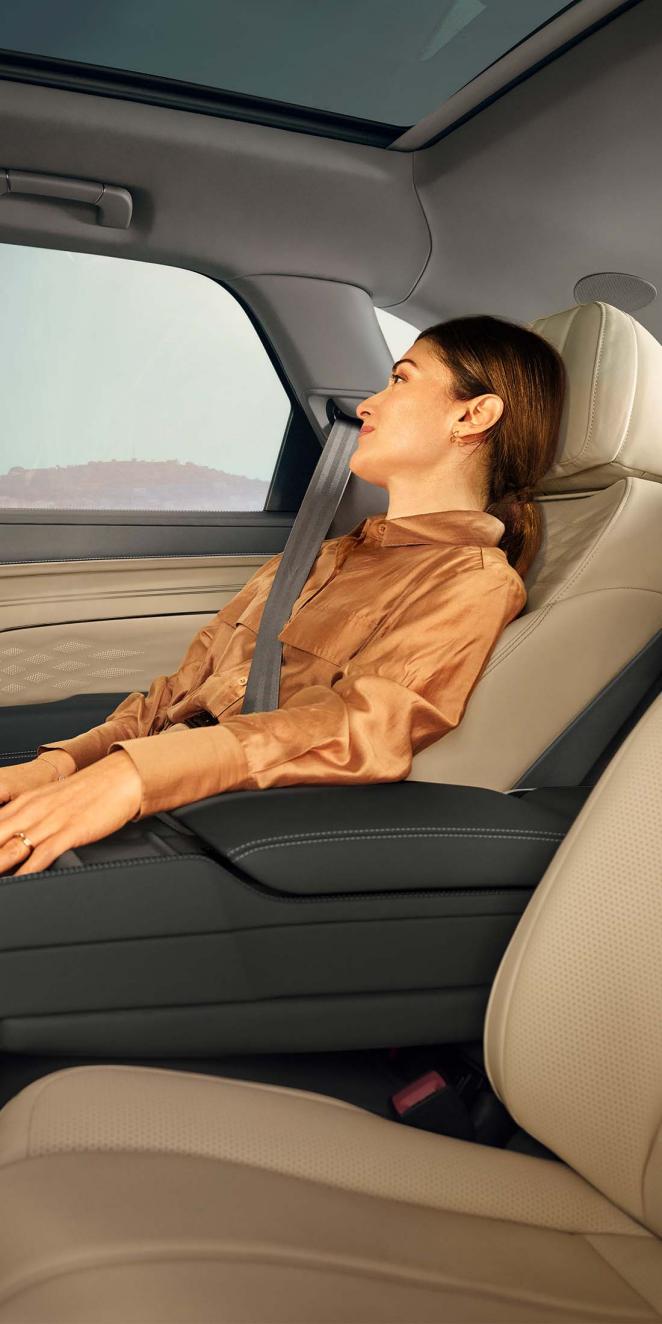 Rear passenger seat view of Bentley Bentayga in Portland Hide and Beluga Hides with a female occupant looking outside the window.