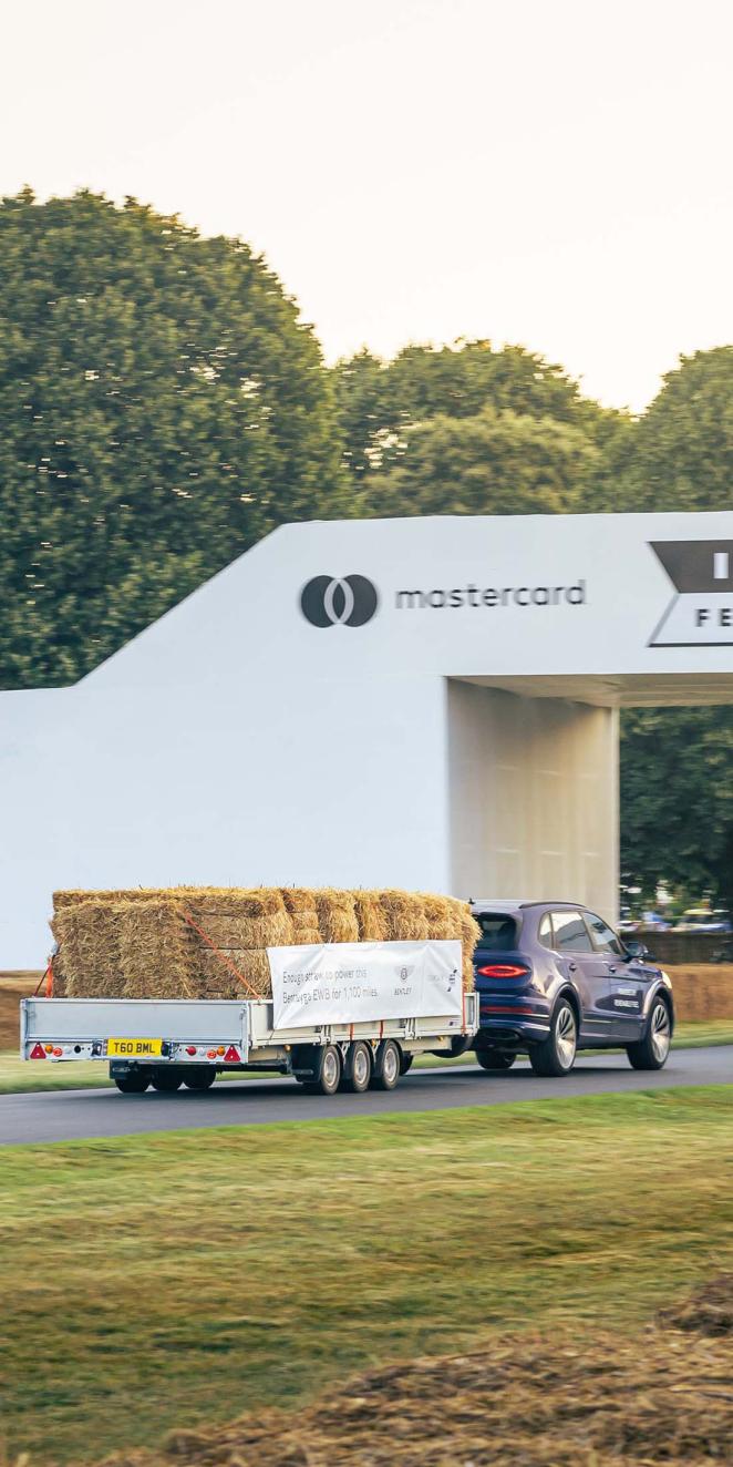 Bentley Bentayga EWB Mulliner in Tanzanite Purple colour reversing with trailer full of hay stack