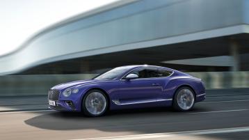 Zoomed out view of Bentley Continental GT Mulliner in Tanzanite Purple colour featuring 22 inch Mulliner Wheel Painted and Polished driving on a highway.