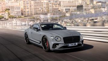 Front side angled view of Bentley Continental GT S in Cambrian Grey, with Black gloss radiator matrix grille with black surround driving on a race track.
