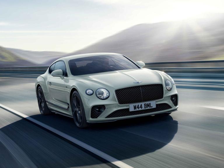 Bentley Continental GT Speed Edition 12 in Arctica (Solid) colour featuring Dark tink radiator matrix and Bentley Wings Badge to bonnet driving along a highway.