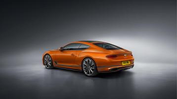 Rear side angled view of Bentley Continental GT Speed in Orange Flame featuring sports exhaust and Chrome Bentley wing badge to boot.
