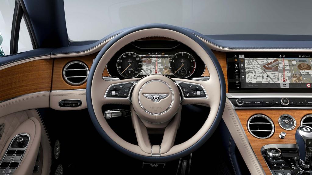 Driver side view of Bentley Continental GT Azure, with Heated, single tone, 3-spoke, hide-trimmed steering wheel in view set in Open pore Crown Cut Walnut veneer.