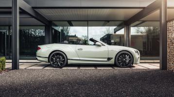 Side view of a parked Bentley Continental GTC Speed Edition 12 in Glacier White featuring featuring 22" Speed alloy wheel – black painted and Speed 12 fender badge.