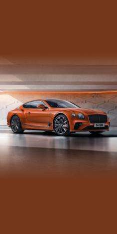 Front side angled view of Bentley Continental GT Speed W12 in Orange Flame colour, featuring 22 inch Speed Wheel - Dark Tint and Black gloss radiator matrix grille with black surround.