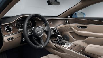 Driver side view of Bentley Flying Spur A V8 overlooking passenger side, featuring Open Pore Crown Cut Walnut veneer and Portland hide.