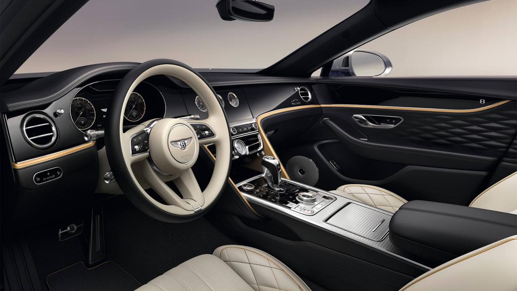 "View over looking driver's seat of Bentley Flying Spur Mulliner featuring Heated, Duo-Tone, 3 Spoke, Hide Trimmed Steering Wheel with Piano Black Veneer. "