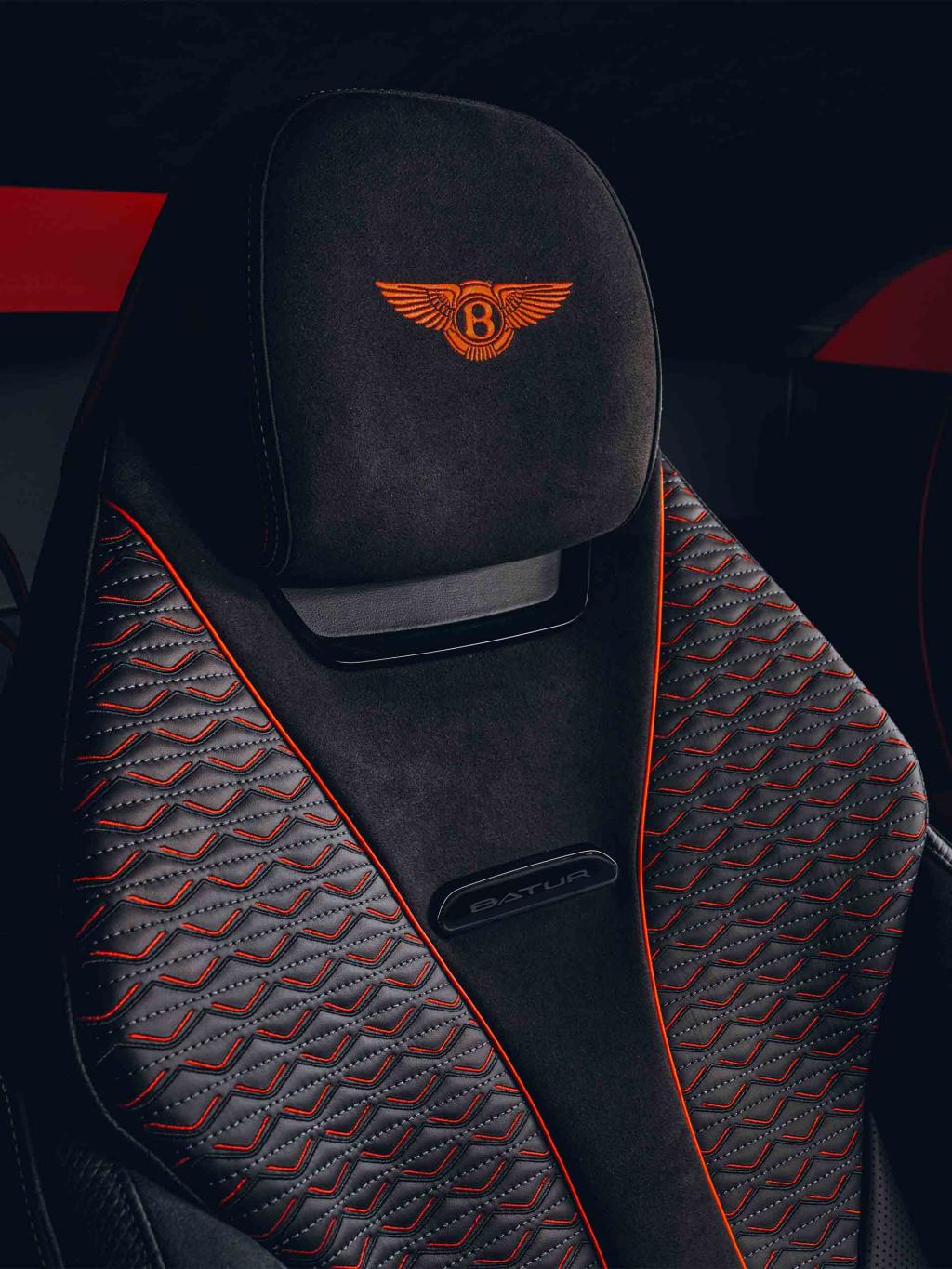 Close up view of Bentley Batur's seat in duo tone Beluga and Hotspur hide with contrast piping and Bentley wings emblem to head rest