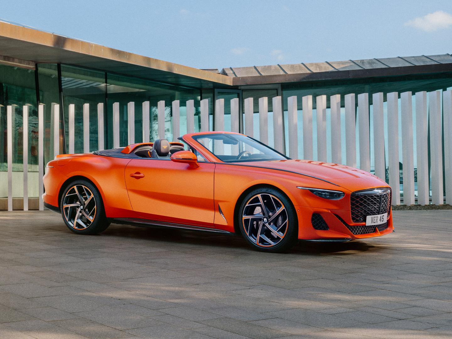 Mulliner Batur rear side angled view featuring Matt black griller with orange surround, Bentley branded red brake callipers set in 22 inch alloy wheels.