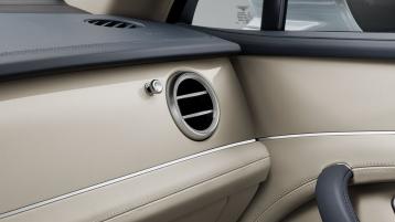 Rear passenger seats of Bentley Bentayga Mulliner in 4 seat specs featuring Linen Hide with Mulliner Console Bottle Cooler and 2 champagne glasses in view.