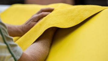 Close up of hands working on leather in dream factory