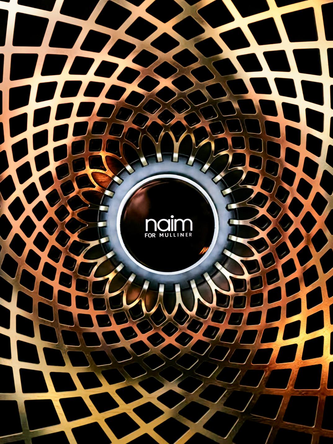 A close up of the new Naim by Mulliner speaker grille in a bespoke gold finish by Mulliner