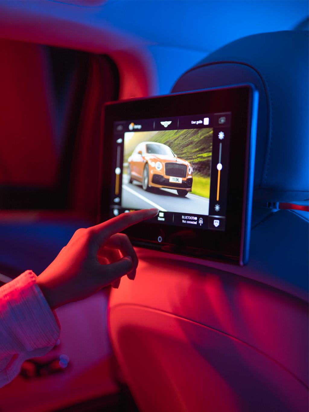Passenger interacting with 10.1 inch Rear Entertainment System featured in Bentley Flying Spur