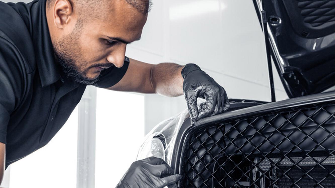 A Bentley trained PPF technician applying PPF to the front of a Bentley Bentayga