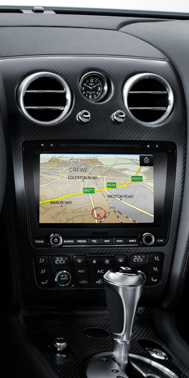 First Generation Bentley Continental GT driver side view, with mono tone steering wheel and center console in view focused on the advanced infotainment system.