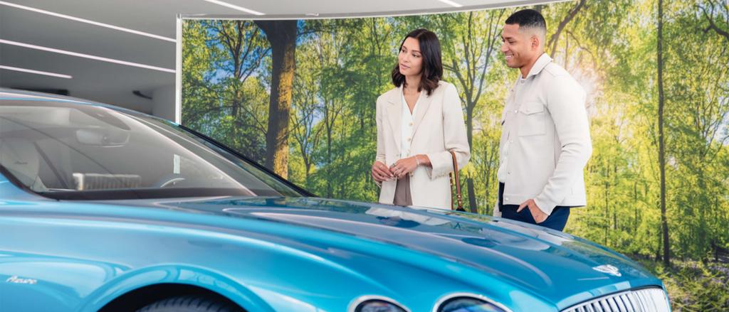 Two people admiring Bentley Continental GT Azure in Imperial Blue, parked in Bentley Dealership.