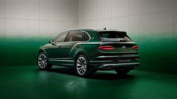 Wisdom Kaye standing next to the rear three quarter of the Bentayga Atelier Edition in an Emerald exterior colours with bright chrome accents