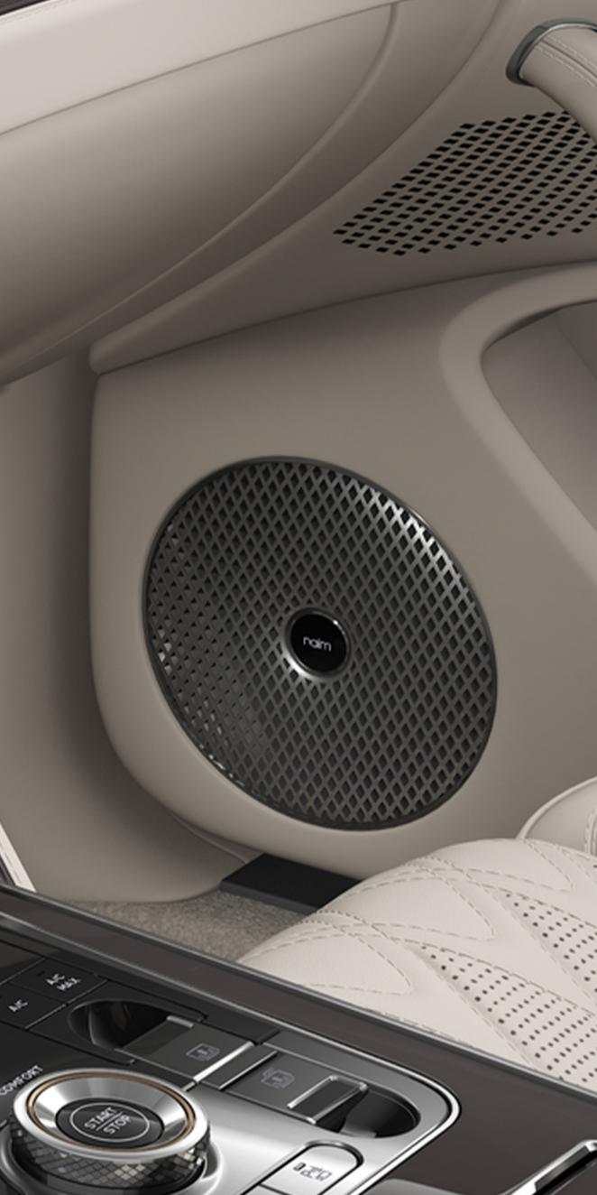 Close-up of the Naim speaker inside the Bentley Flying Spur Azure with Linen and Burnt Oak interior trim.