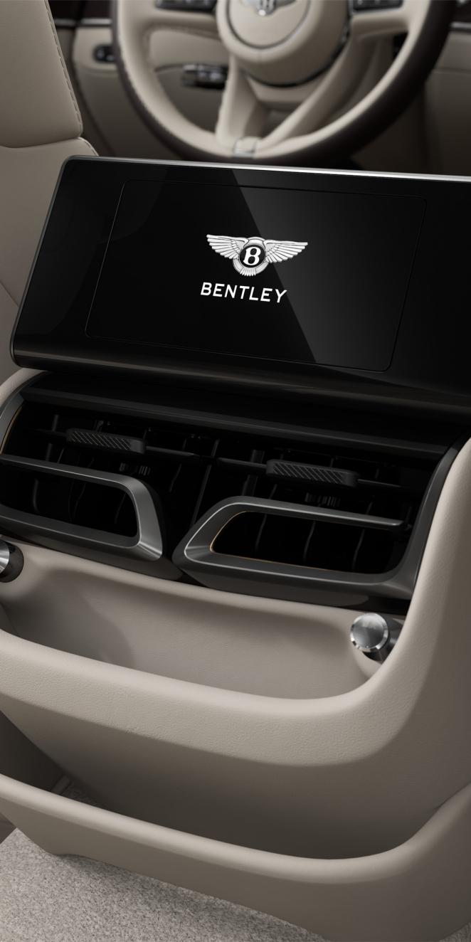 Rear passenger digital screen inside the Bentley Flying Spur Azure with Linen and Burnt Oak cabin trim.