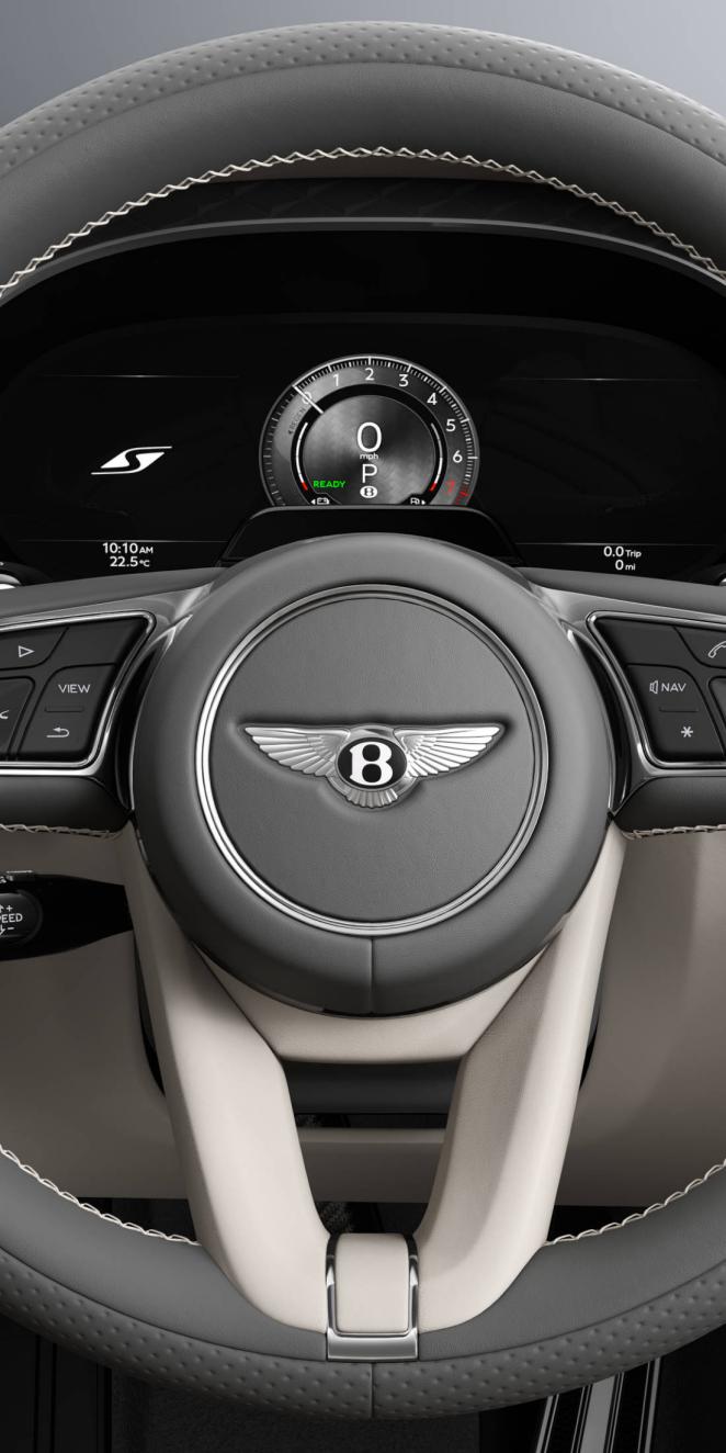 Close up of the driver’s view of the Bentley Flying Spur S steering wheel with Linen and Gravity Grey interior trim.
