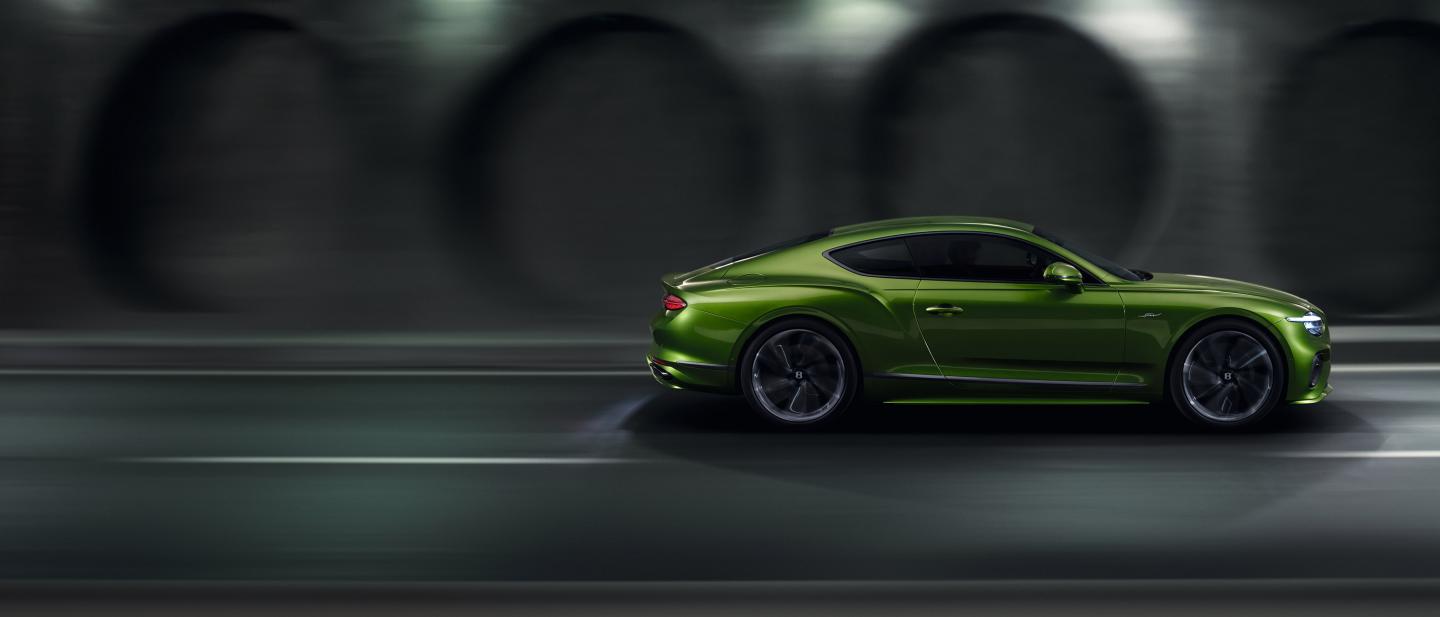 Side profile of a Tourmaline Green Continental GT Speed driving through a tunnel dynamically